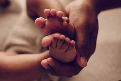 Newborn-feet-in-dads-hand-by-Lifetime-Stories-Photography