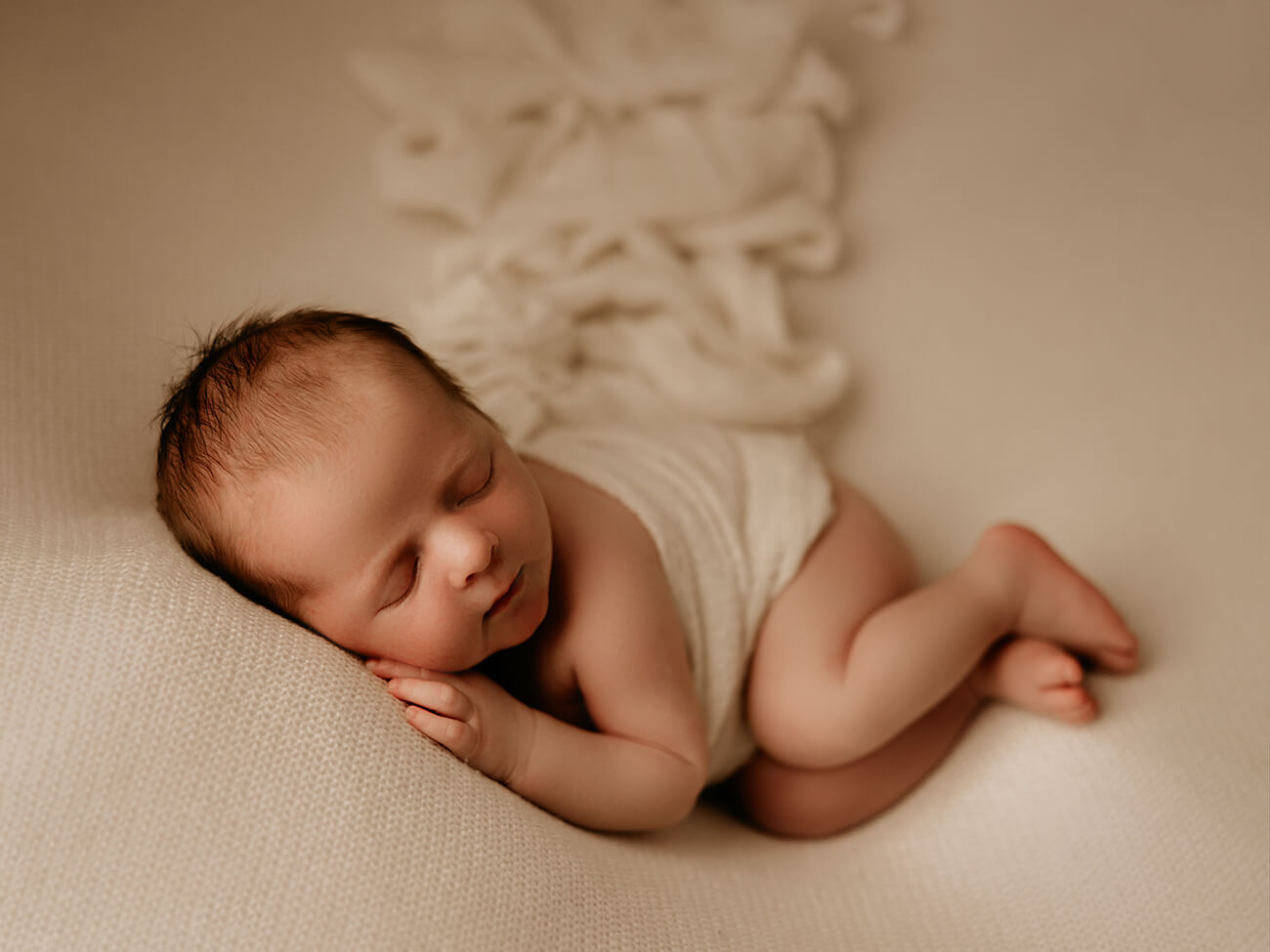 newborn baby boy sleeping on his side photographed in cream colours by Lifetime Stories Photography Brisbane studio